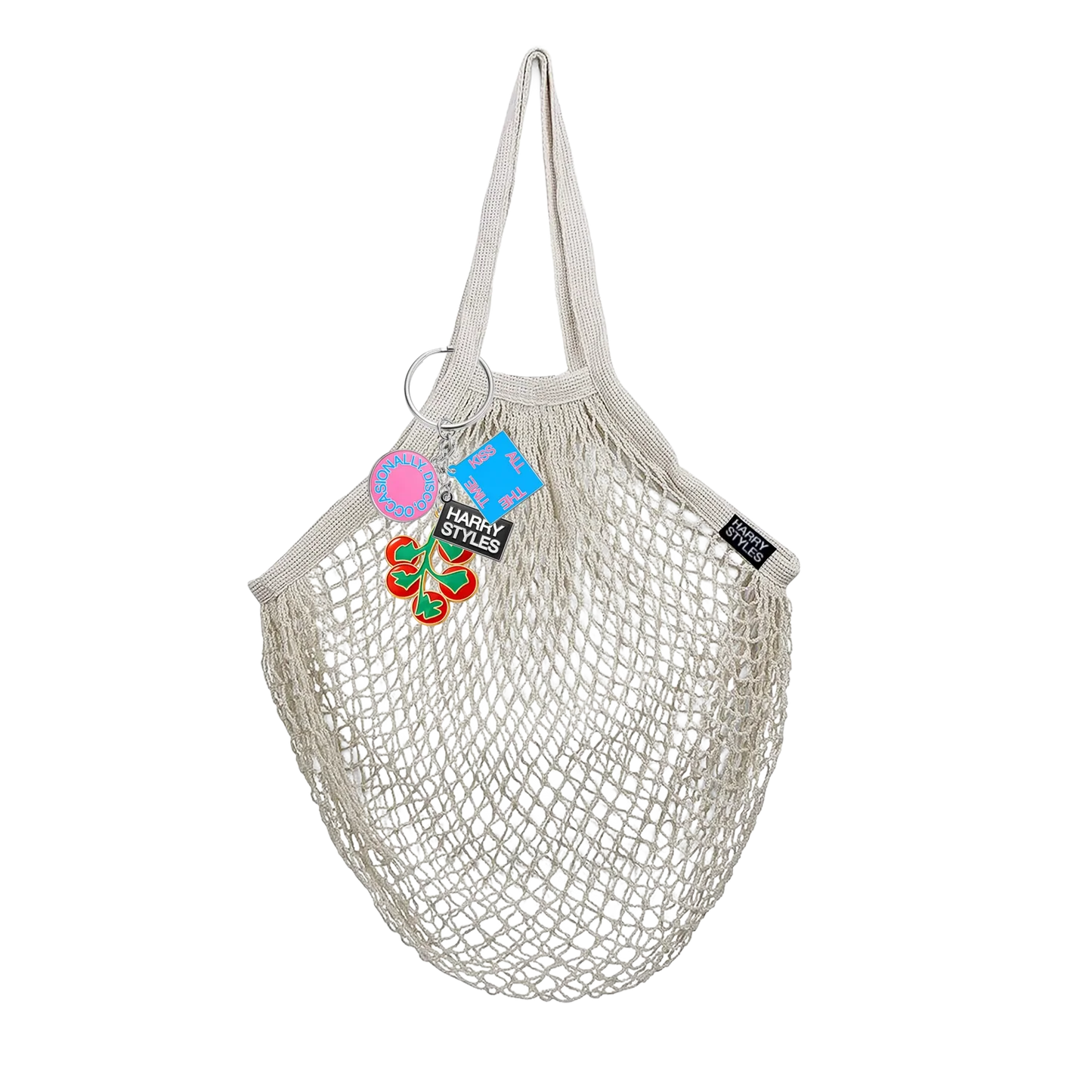 Natural cotton mesh grocery bag from Harry Styles merchandise featuring tomato keychain charms and collectible branded tags attached to handle ring